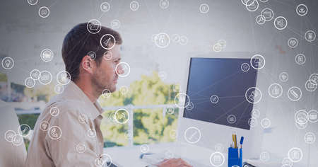 Composition of network of connections with icons over businessman using computer in office. global connections, data processing, computing and technology concept digitally generated image.の写真素材