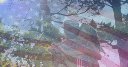 Composition of male soldier embracing smiling daughter over american flag. soldier returning home to family concept digitally generated image.の写真素材