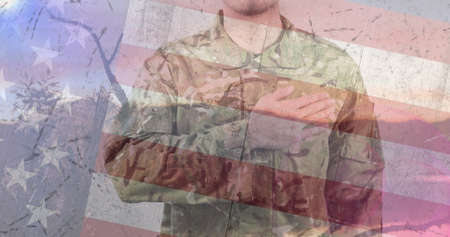 Composition of male soldier swearing with hand on heart over american flag. patriotism and celebration concept digitally generated image.の写真素材