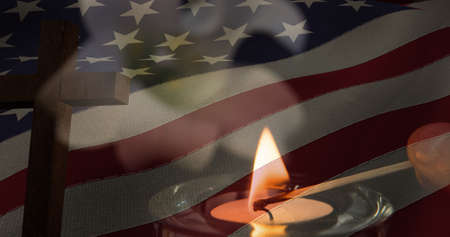 Composition of crucifix and candle over american flag. american patriotism and religion concept digitally generated image.の写真素材