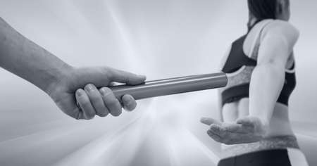 Black and white image of hand passing a baton to female athlete against stretch effect background. sports and fitness conceptの写真素材