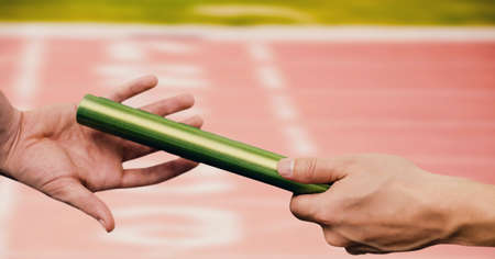 Composition of midsection of caucasian athletes passing green relay baton. sports and competition concept digitally generated image.の写真素材
