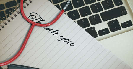 Composition of thank you note with stethoscope over computer keyboard. medicine and healthcare...
