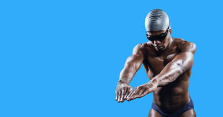 Composition of male swimmer with copy space isolated on blue background. sports and competition concept digitally generated image.の写真素材