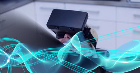 Blue digital waves against caucasian woman wearing vr headset against grey technology background....