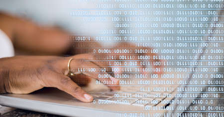 Binary coding data processing against mid section of person using laptop. global business and cyber security technology conceptの写真素材