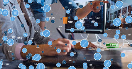 Network of digital icons against mid section of businessman and businesswoman working together....