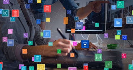 Network of digital icons against mid section of businessman and businesswoman working together. global networking and business technology conceptの写真素材