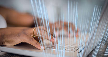 Blue glowing light trails against mid section of person using laptop. global business and technology...
