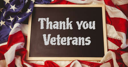 Composition of text thank you veterans in white on chalkboard on crumpled american flag. patriotism, independence and celebration concept digitally generated image.の写真素材