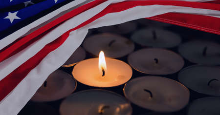 Composition of lit tea light sitting on other candles, with american flag. patriotism, independence and celebration concept digitally generated image.の写真素材