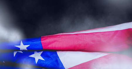 Composition of american flag billowing with smoke on dark background. patriotism, independence and celebration concept digitally generated image.の写真素材