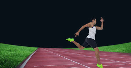 Caucasian male athlete running on sports field against black background. sports competition and...