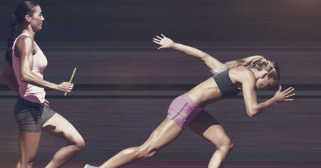 Two diverse female athletes holding baton running against grey background. sports competition and...