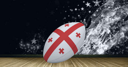 Georgia flag on rugby ball over wooden surface against smoke effect and stars on black background. sports tournament and competition conceptの写真素材