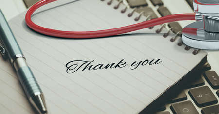 Thank you text, stethoscope and pen over a diary against laptop keyboard in background. healthcare love and support conceptの写真素材