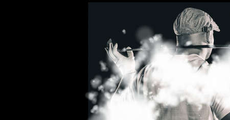 Rear view of senior male golf player holding gold club against smoke effect on black background....