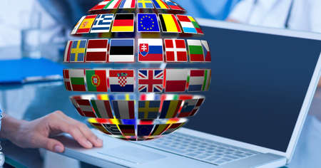 Globe of flags of multiple european countries against mid section of man using laptop at office. eu union conceptの写真素材