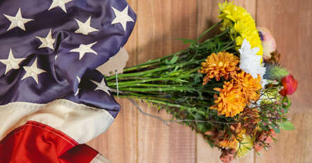 American flag and bunch of flowers on wooden background. american patriotism template background design conceptの写真素材