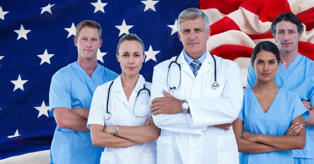 Composition of smiling diverse team of medical workers over billowing american flag. patriotism,...