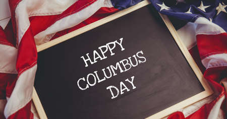 Happy columbus day text on wooden slate against american flag in background. columbus day template background design conceptの写真素材