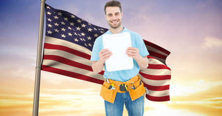 Composition of smiling male construction worker over billowing american flag and sunset sky. patriotism, independence and labor day celebration concept digitally generated image.の写真素材