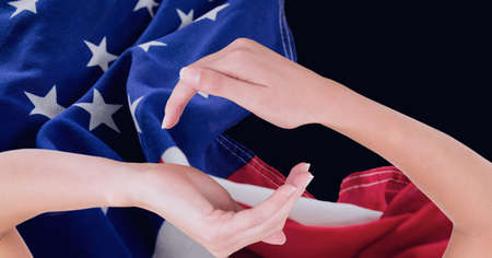 Composition of two hands cupped above and below with billowing american flag on black. patriotism, independence and celebration concept digitally generated image.の写真素材