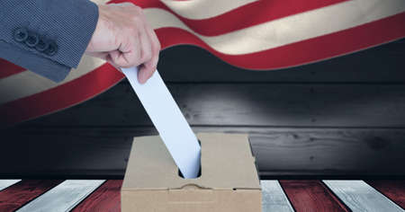 Composition of man casting vote into ballot box against american flag. united states of america...