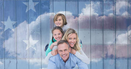 Composition of portrait of smiling caucasian couple with son and daughter against american flag....