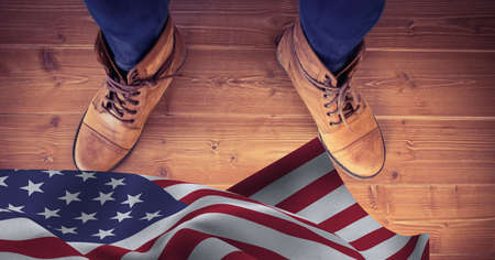 Composition of feet in work boots and american flag, on wooden floor. patriotism, independence and labor day celebration concept digitally generated image.の写真素材