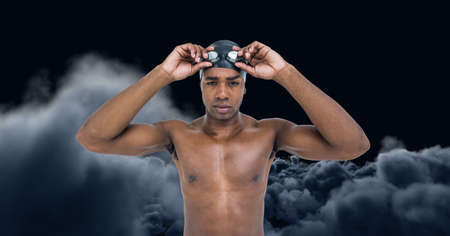 Composition of male swimmer over clouds on black background. sport and competition concept digitally generated image.の写真素材