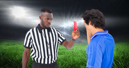 Composition of male referee with yellow card and player at football stadium. sport and competition concept digitally generated image.の写真素材