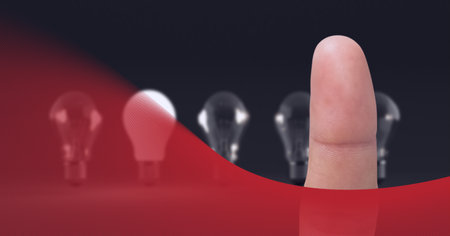Composition of finger touching lit light bulb with row of light bulbs on grey background. global...