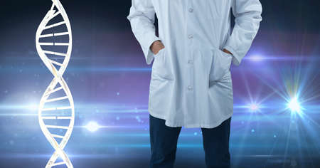 Mid section of male doctor against dna structure and spots of light on blue background. medical research and science technology conceptの写真素材