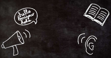 Image of hand drawn white speech bubble with Hello, Bonjour and Hola text with linguistics school subject icons on black chalkboard. Education and schooling concept digitally generated image.の写真素材