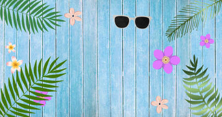 Composition of exotic leaves, sunglasses and flowers with copy space on wooden background. summer, exotic nature and colour concept digitally generated image.の写真素材