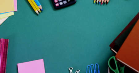 Digital image of Graduation hat and diploma icon over various school items against green background