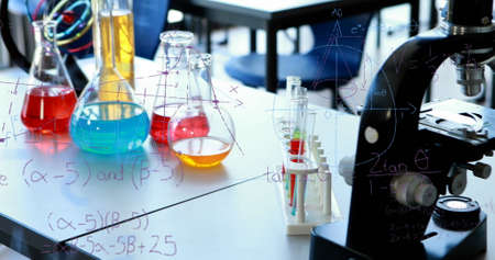 Image of mathematical equations floating over chemical equipment and model of chemical structure with classroom in the background. Education back to school concept digitally generated image.の写真素材