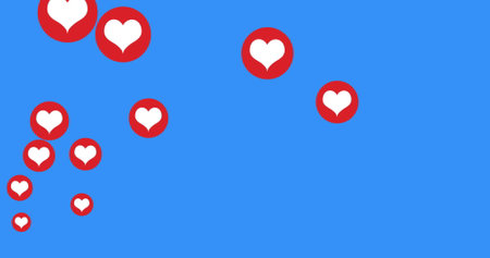 Image of heart digital icons floating and two women wearing face masks social distancing on blue...