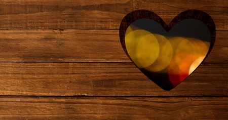 Image of glowing lights seen through heart shape cutout. christmas festivity celebration concept digitally generated image.の写真素材