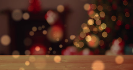 Image of red and orange shapes floating over a christmas tree standing with fairy lights flashing. Christmas winter concept digital compositionの写真素材