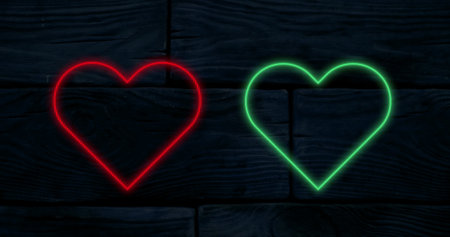 Image of red and green neon hearts flashing on a black background. valentine's day, love and romance concept, digitally generated image.の写真素材