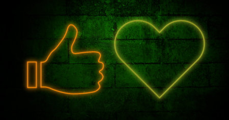 Image of orange and yellow neon socila media symbols flashing on dark brick wall background. social media communication concept, digitally generated image.の写真素材