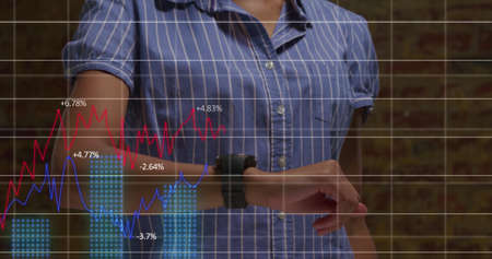 Image of a businesswoman and businessman using smartwatch and digital tablet with stock market...