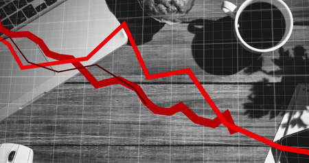 Red graphs moving over grid network against laptop and coffee cup on wooden surface. global finance...