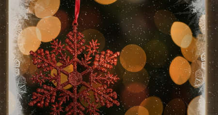 Image of red christmas decoration with snow falling and lights. christmas celebration festivity concept digitally generated image.の写真素材