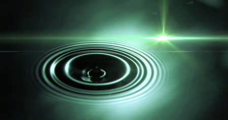 Digital image of spot of light against water drop falling against green background. computer interface and technology conceptの写真素材