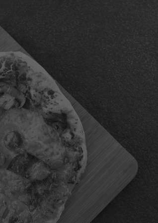 Composition of close up of fresh black and white pizza on gray background. food menu and template concept digitally generated image.の写真素材