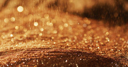 Gold glitter gems spilling on black background. christmas new year's eve party festivity...