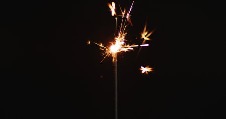 Lit party sparkler sparkling on black background. christmas new year's eve party festivity...
